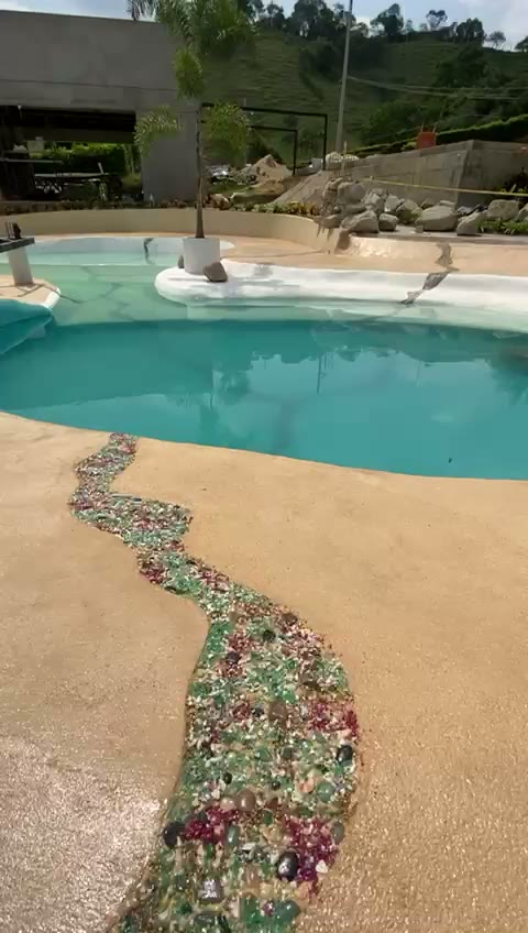 Piscina tipo playa con entrada de arena y agua turquesa