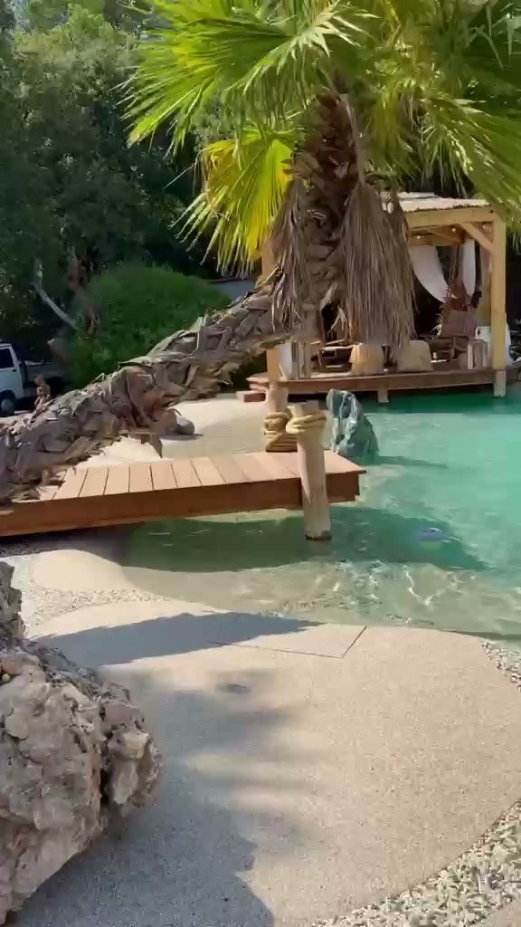 Piscina tipo playa estilo resort con agua turquesa y acceso de arena