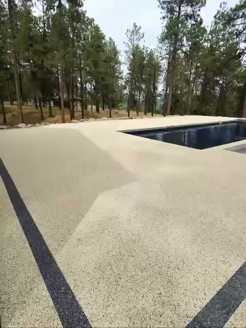 Piscina de lujo con contorno drenante rodeada de pinos